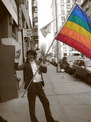 Sylvia Rivera con una bandera arco iris.