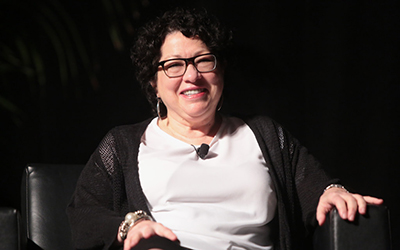 Sonia Sotomayor vestida en blanco y negro sentada en una silla.