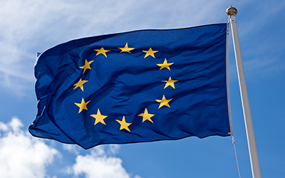 La bandera de la unión europea. Una bandera con fondo azul y un círculo de 12 estrellas amarillas.