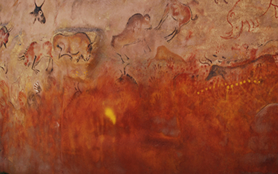 Una pintura prehistórica que tiene dibujos de animales como el bisonte y que usa mucho rojo.