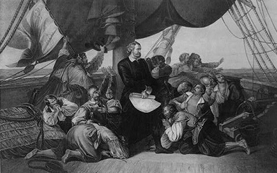 Una imagen en blanco y negro de Cristobal Colón con su tripulación en un barco.