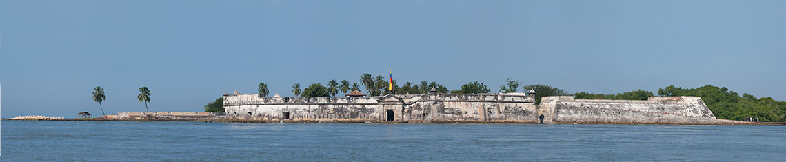 un panorama de la fortaleza de San Fernando, en la entrada a la bahía de Cartagena (conocida como Boca Chica). La fortaleza ocupa el centro de la foto y el mar la rodea.