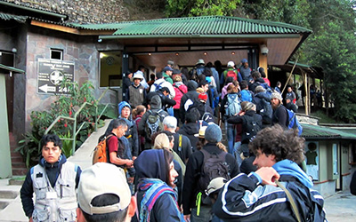 Una cola de personas afuera de un edificio esperando entrar a Machu Picchu.