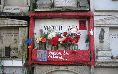 Un cuadro de cemento con orilla roja que dice, “Victor Jara hasta la victoria” en el Cementerio General en Santiago Chile.