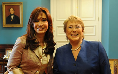 Cristina Fernández de Kirchner y Michelle Bachelet sonriendo en una oficina en el Palacio de la Moneda.