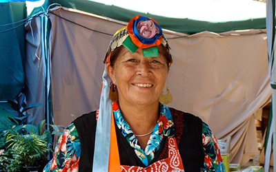 Una mujer indígena con vestimenta tradicional sonriendo.